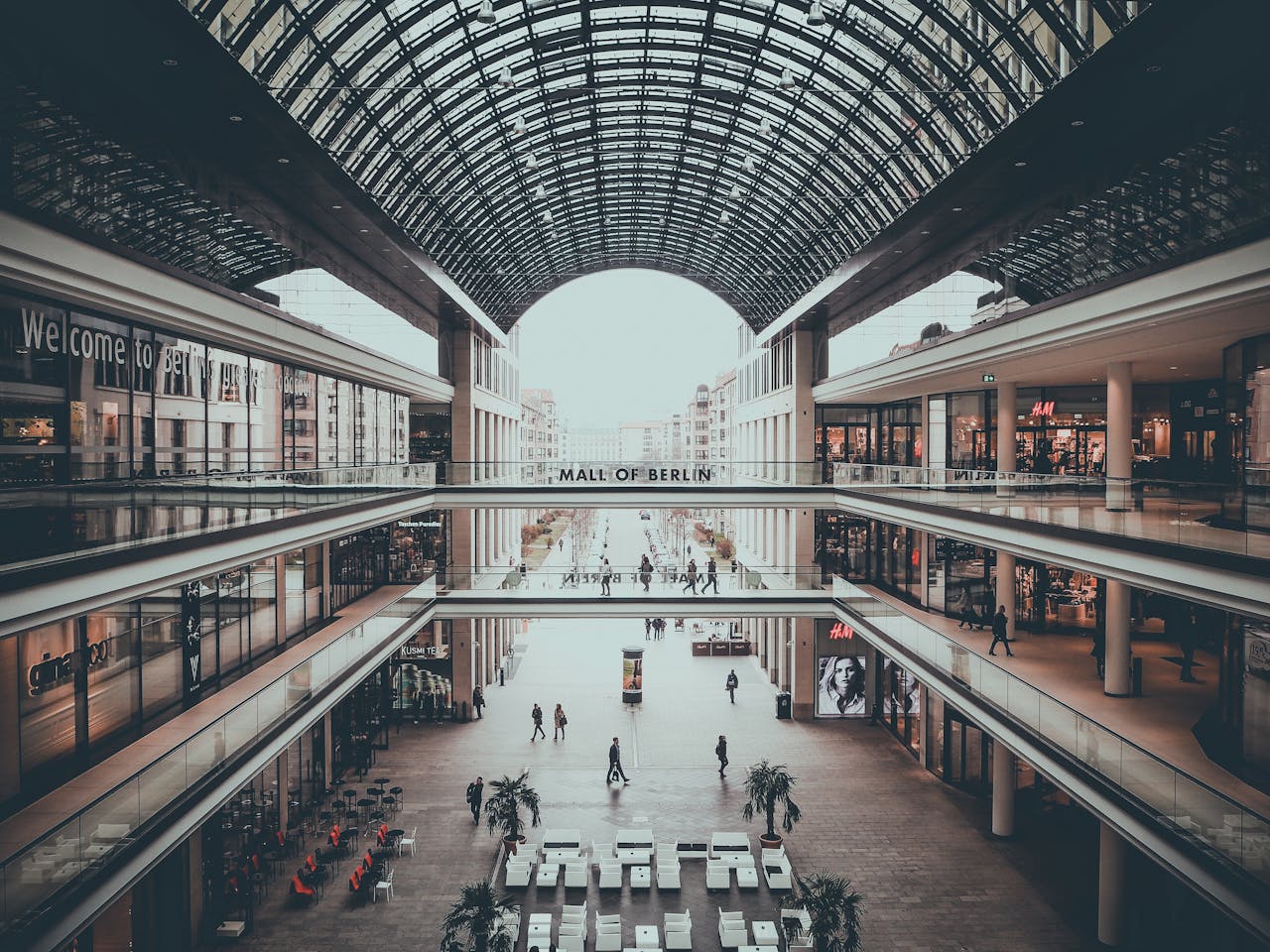 Explore the sleek and multi-level design of Mall of Berlin, showcasing modern architecture and shoppers.